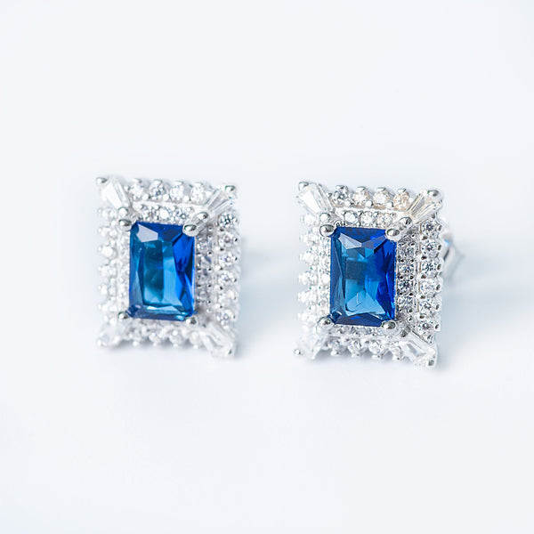 A close up view of Diana earrings standing against a white background. 
