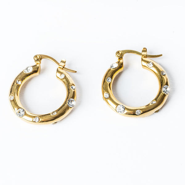 A pair of yellow gold hoop earrings embellished with cubic zirconia gems.