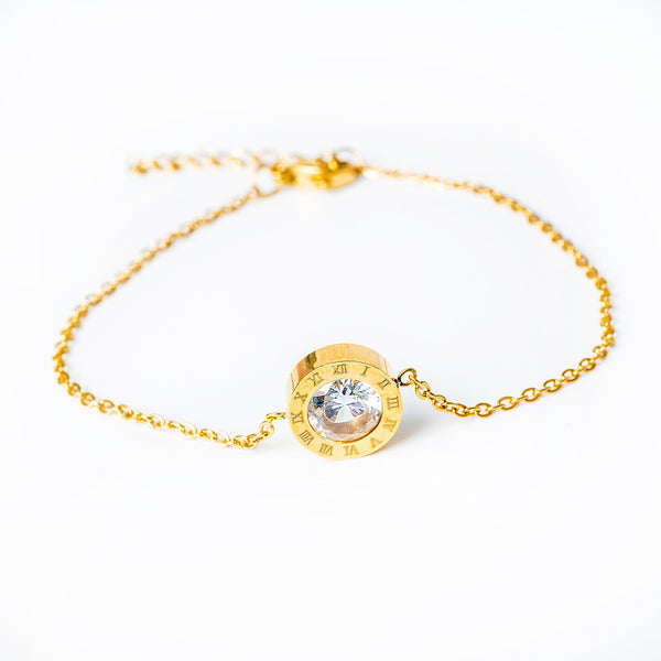A close up view of Ester Gold Bracelet standing in the center of the image against a white background. 