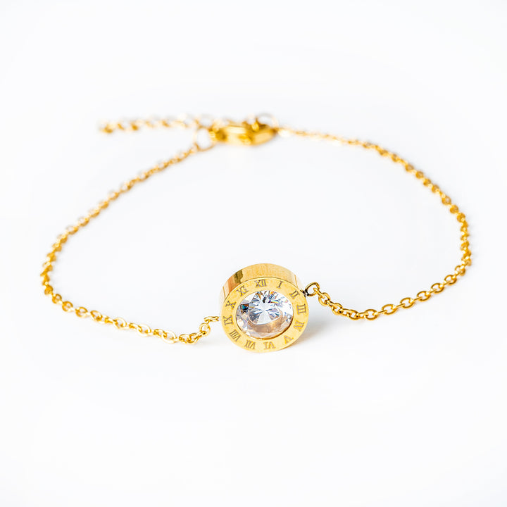 A close up view of Ester Gold Bracelet standing in the center of the image against a white background. 