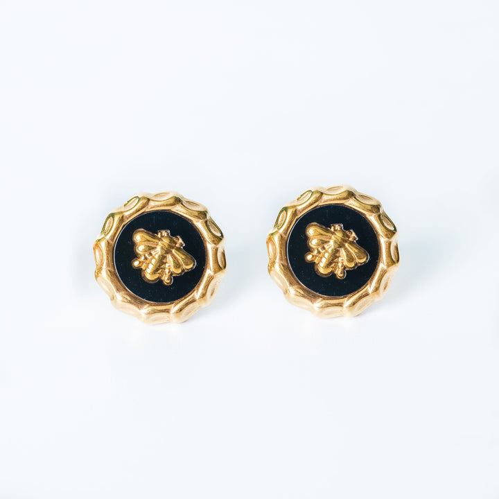 Gold Evelyn bee stud earrings with black enamel displayed on a white background