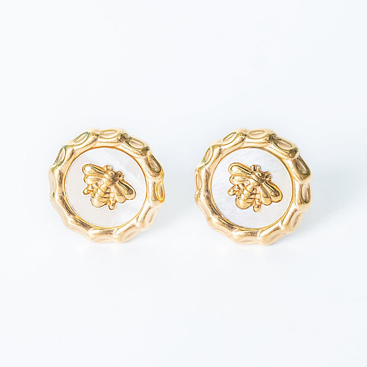 Gold Evelyn bee stud earrings with white enamel displayed on a white background