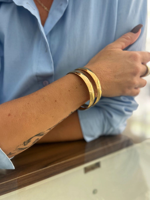 A person's forearm wearing Fili Lixxi bangles with a textured surface.