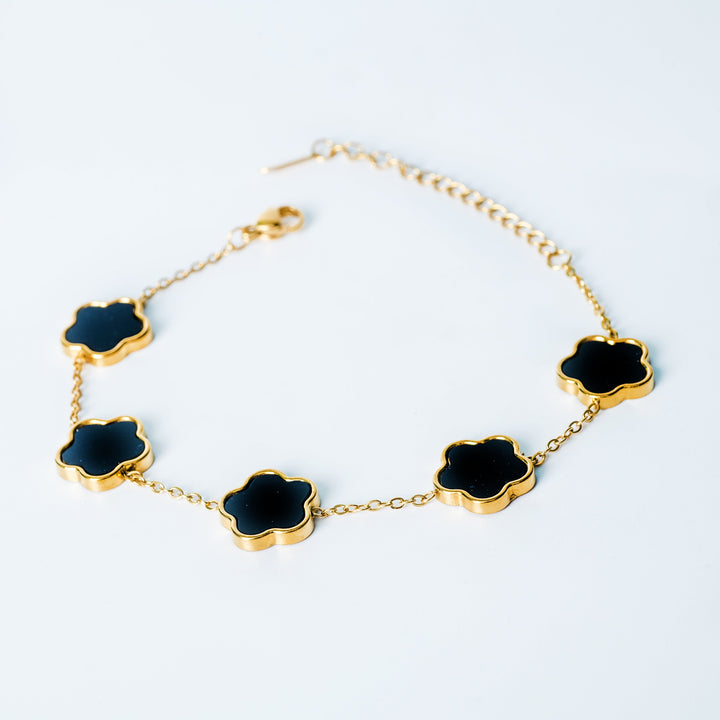 Gold Fiore bracelet featuring black flower-shaped links on a white background