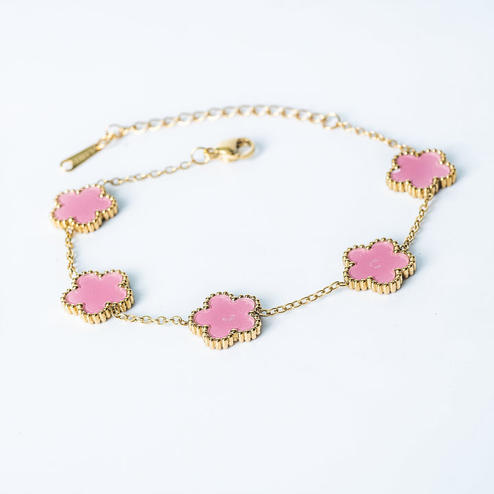 Gold Fiore bracelet featuring pink flower-shaped links on a white background