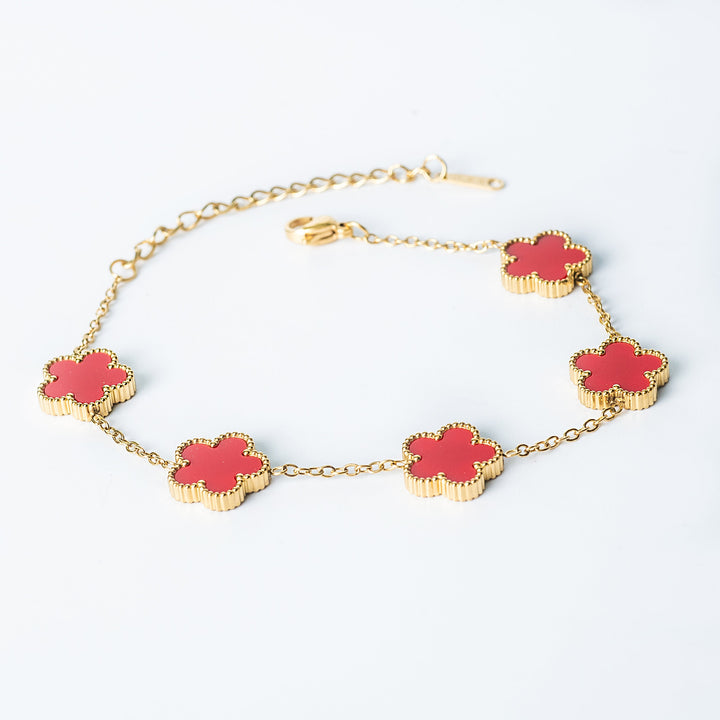 Gold Fiore bracelet featuring red flower-shaped links on a white background