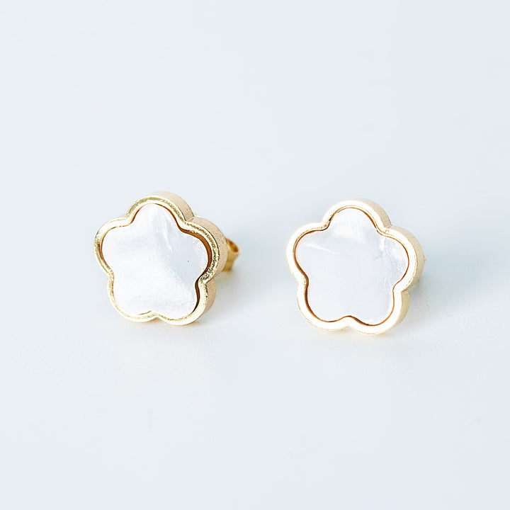 Gold Fiore stud earrings featuring white mother-of-pearl flower fronts on a white background