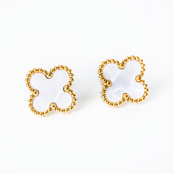 a white colour earrings standing in the center of the image. 
