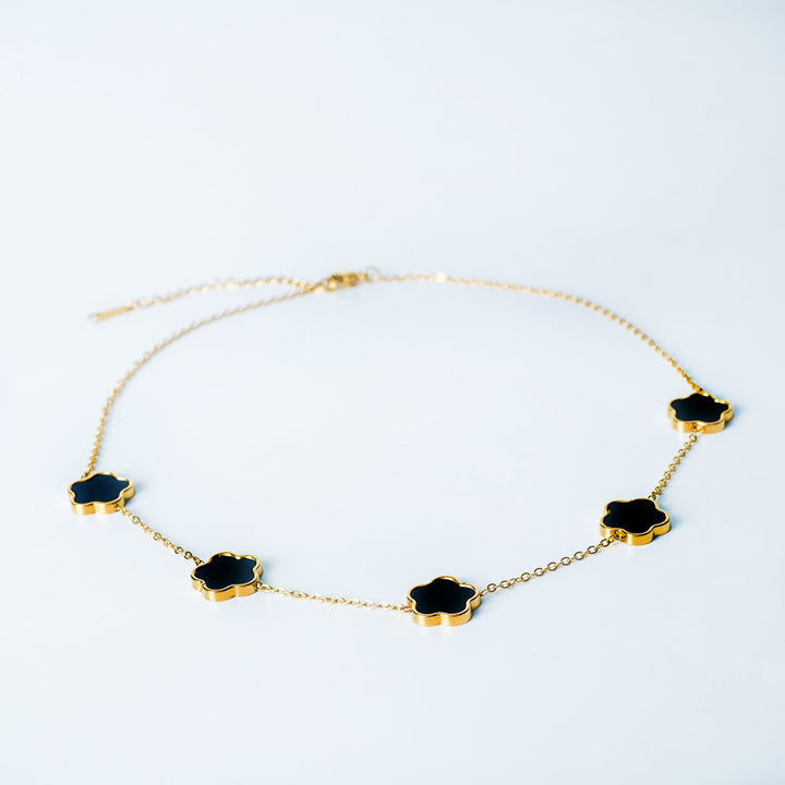 Gold Fiore necklace featuring black flower-shaped links on a white background