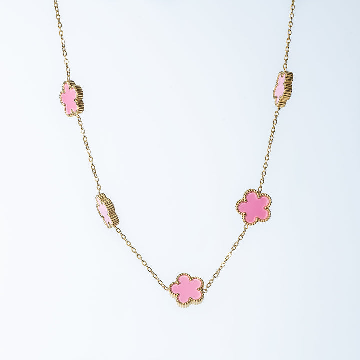 Gold Fiore necklace featuring pink flower-shaped links on a white background