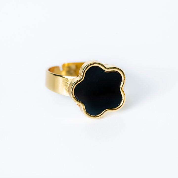 Gold Fiore ring featuring a black flower-shaped centerpiece on a white background