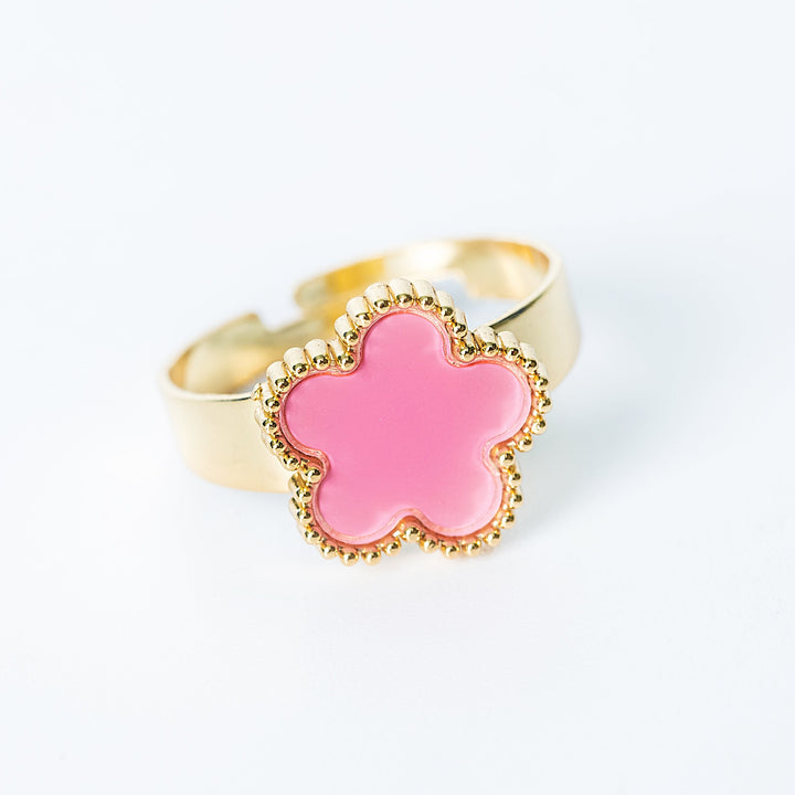 Gold Fiore ring featuring a pink flower-shaped centerpiece on a white background