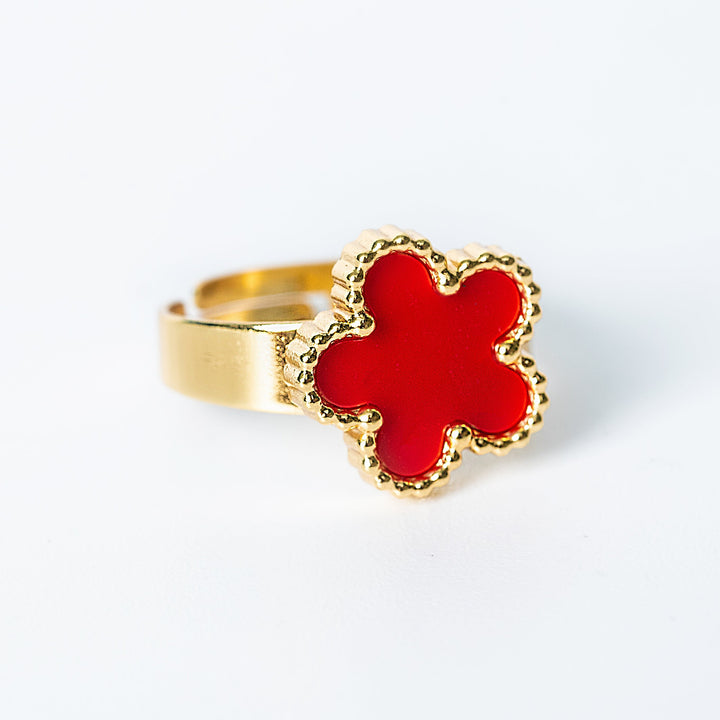Gold Fiore ring featuring a red flower-shaped centerpiece on a white background