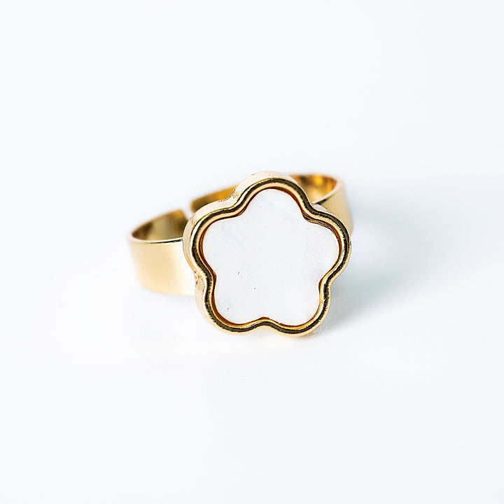Gold Fiore ring featuring a white mother-of-pearl flower-shaped centerpiece on a white background