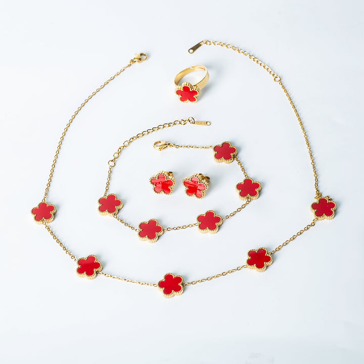 Fiore Set in gold featuring a matching bright red flower necklace, bracelet, earrings, and ring displayed on a white background