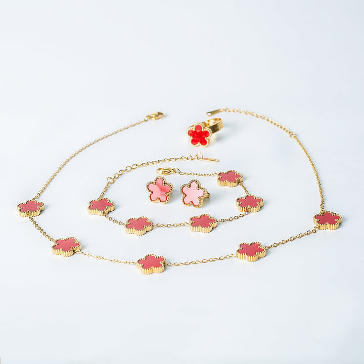 Fiore Set in gold featuring a matching red and pink flower necklace, bracelet, earrings, and ring displayed on a white background