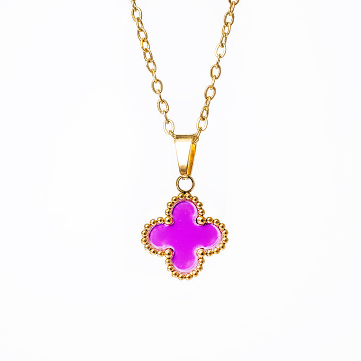 A close up view of Fiore necklace with purple pendant standing in the center of the image against a white background. 