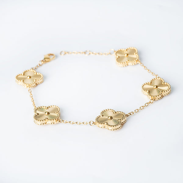 Gold Fiorella bracelet featuring multiple flower-shaped links arranged on a white background