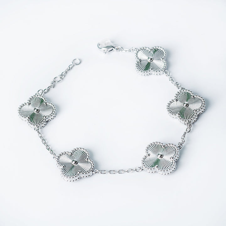 Silver Fiorella bracelet featuring multiple flower-shaped links arranged on a white background