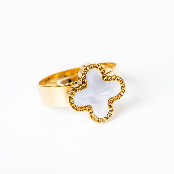 A yellow gold ring with a white enamel centerpiece and small yellow gold accents around the border.