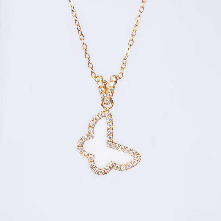 Gold Francesca necklace with a crystal-lined open butterfly pendant shown in a close-up on a light background