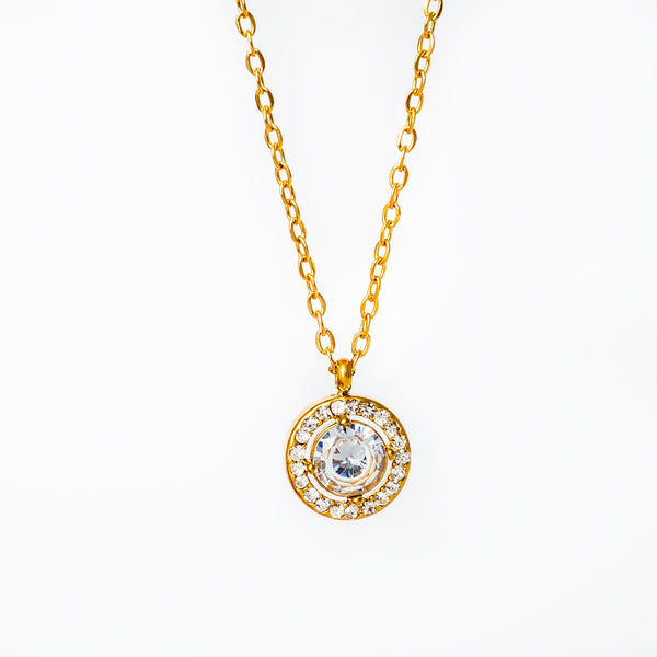 A yellow gold-plated stainless steel necklace with a round pendant featuring a cubic zirconia gemstone.