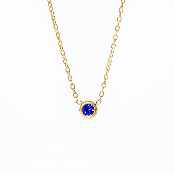 A yellow gold-plated stainless steel necklace with a blue cubic zirconia pendant