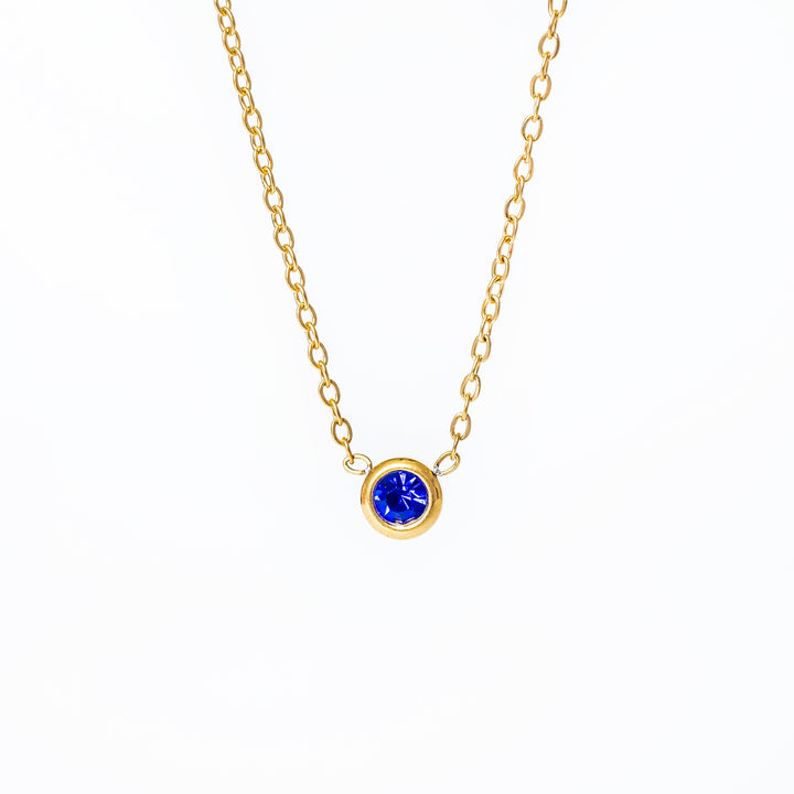 A yellow gold-plated stainless steel necklace with a blue cubic zirconia pendant