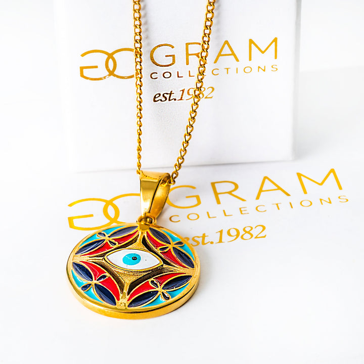 Gold Ghajn necklace with a colorful pendant on a 'Gram Collections' branded background