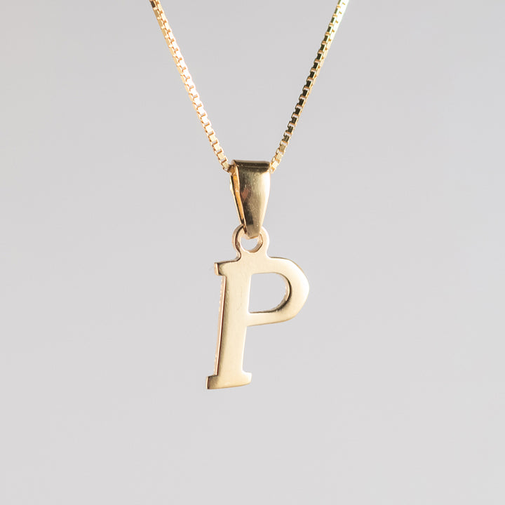A close up view of gold letter pendant  letter p