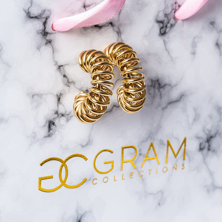 Ines Gold Earrings attached to its uniquely designed gram collections box. 