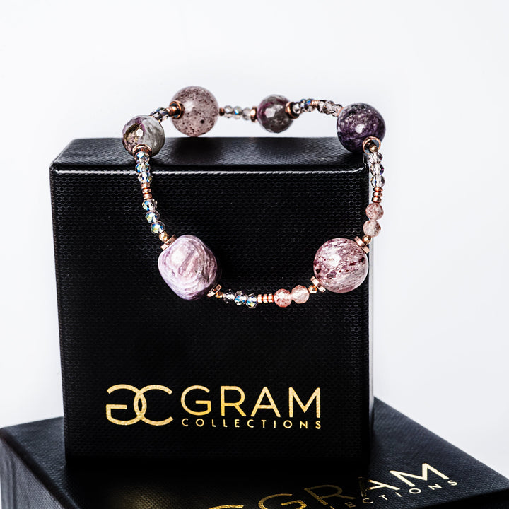 A plum bracelet attached to its box