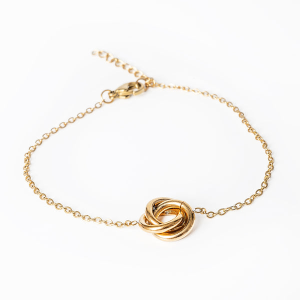 A yellow gold plated stainless steel Carment gold bracelet with an intricate design, featuring a chain-linked structure with a gold-tone bead.