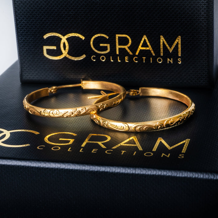 The Gram Collections Sue Earrings standing on top of their original black coloured package. 