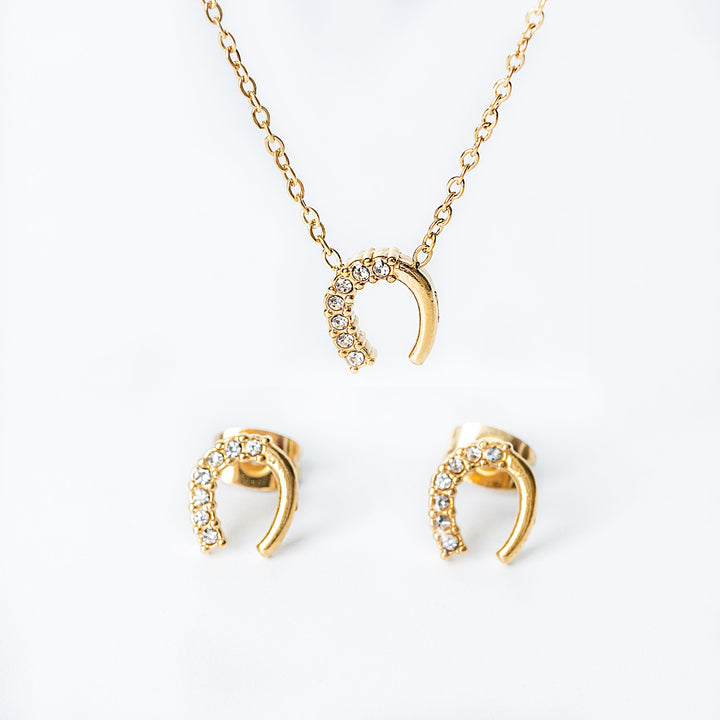 Gold Harper jewelry set featuring a crystal horseshoe necklace with matching stud earrings.
