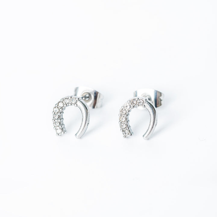 Silver horseshoe stud earrings with small clear crystals arranged along the curve