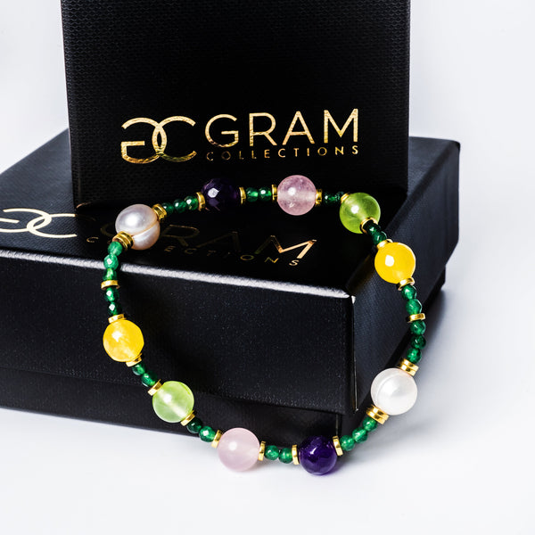 HoneyDew Bracelet placed on the edge of its gram collections black box surrounded by a white background. 
