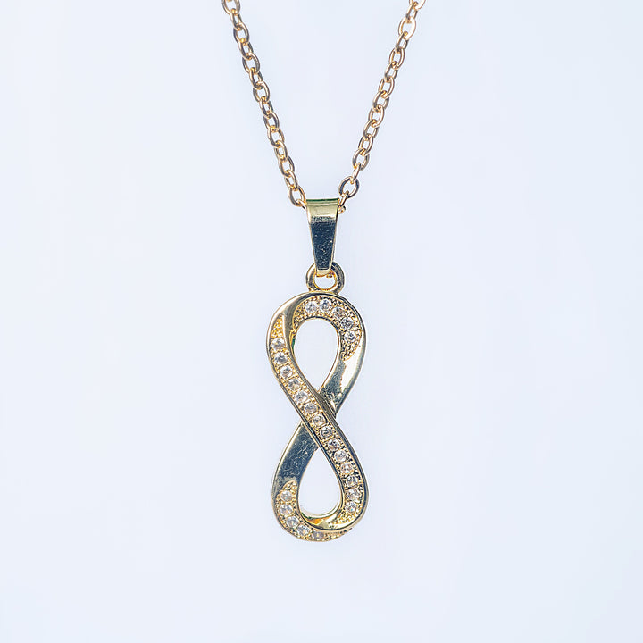Ina gold necklace with crystal infinity pendant in front view
