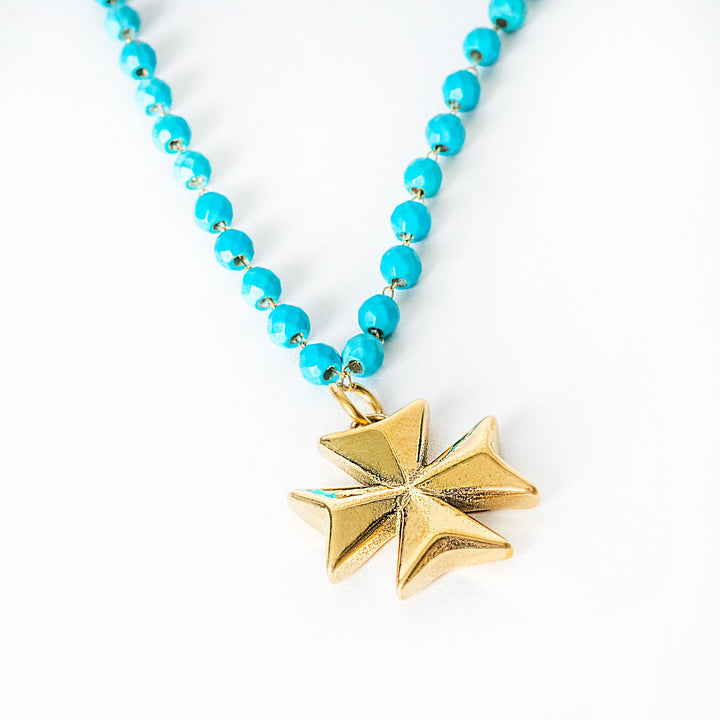 Necklace with turquoise beads and a gold star pendant on a white background