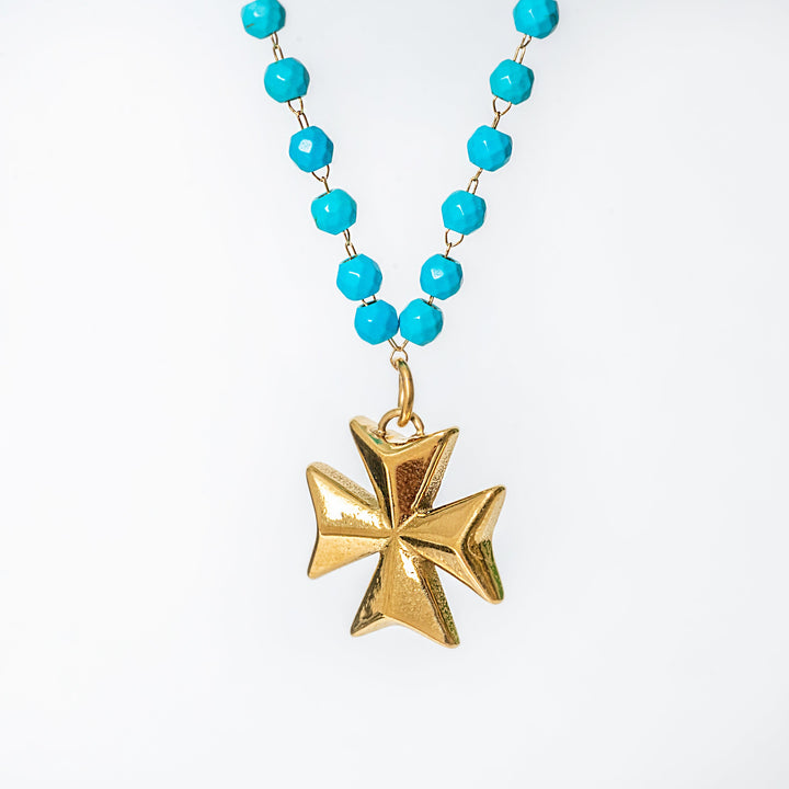 Kahli Necklace with turquoise beads and gold Maltese cross pendant on a white background