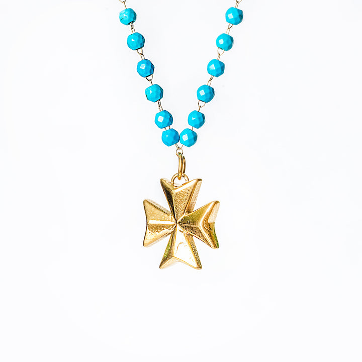 Khali Necklace with turquoise beads and a gold Maltese cross pendant on a white background