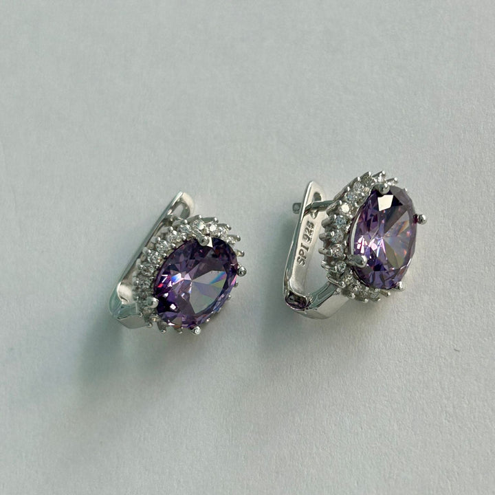 A close up view of Kate earrings purple stone colour standing in the center of the image against a white background. 