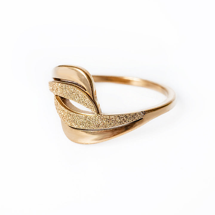A profile view of Kaycee Gold Ring standing in the center of the image against a white background. 