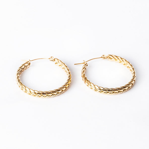 A pair of yellow gold hoop Kelly earrings with a textured surface on a white background.