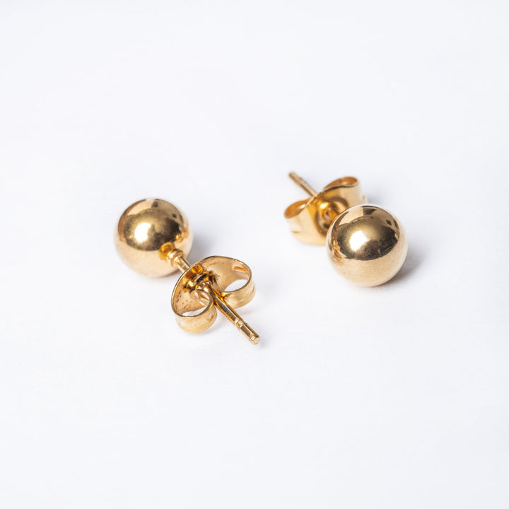A bird view of Kim Earrings, in gold colour, one paced from front, another from rare side, standing in the center of the image against a white background. 