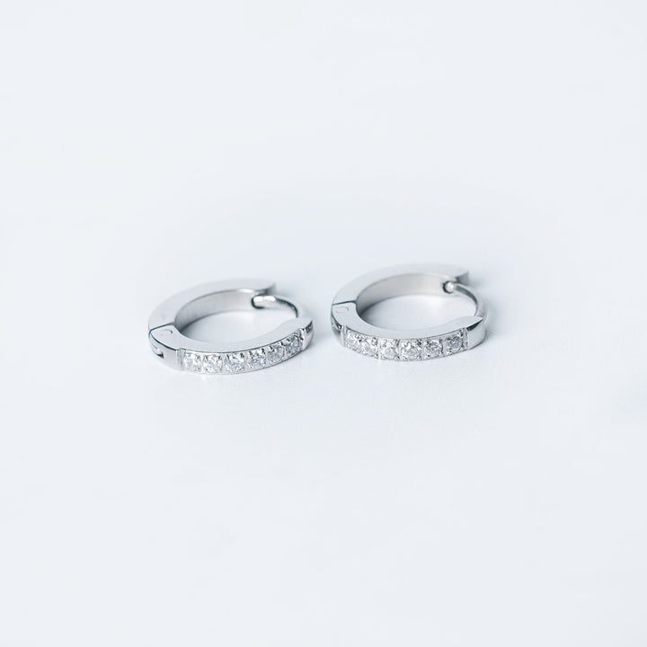 Silver Kyonne hoop earrings with a front row of clear diamonds on a white background