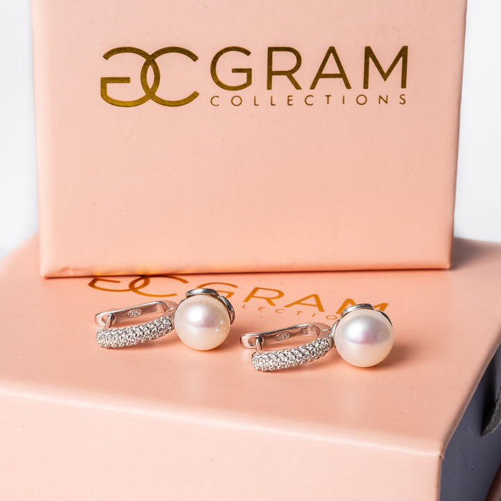 Layla earrings standing on their pink box. 