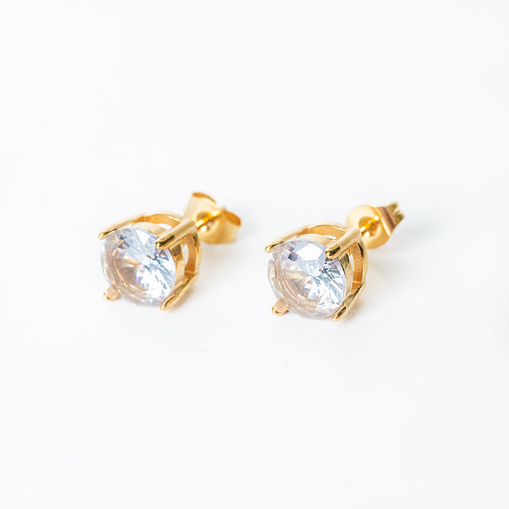 Gold Leia stud earrings with round clear gemstones in a prong setting.