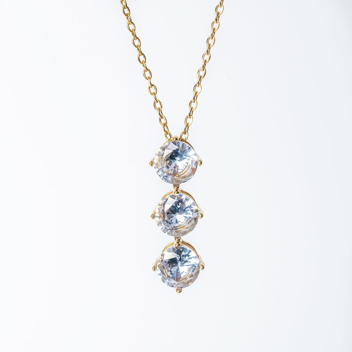 Gold Leia necklace featuring three vertically aligned clear gemstones.