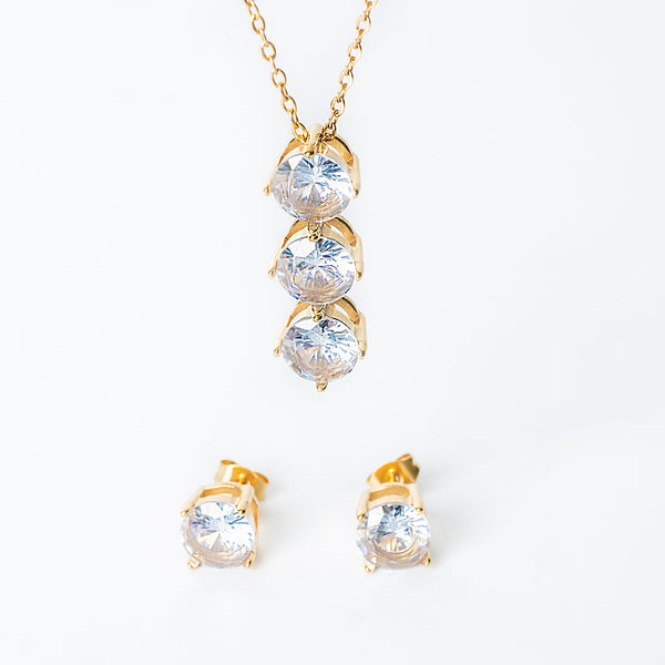 Gold Leia jewelry set featuring a necklace with three clear gemstones and matching stud earrings.